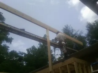 Carpenter setting a ridge beam over a new addition frame — Ice Dam Removal by Roofing Brothers in Chadwicks
