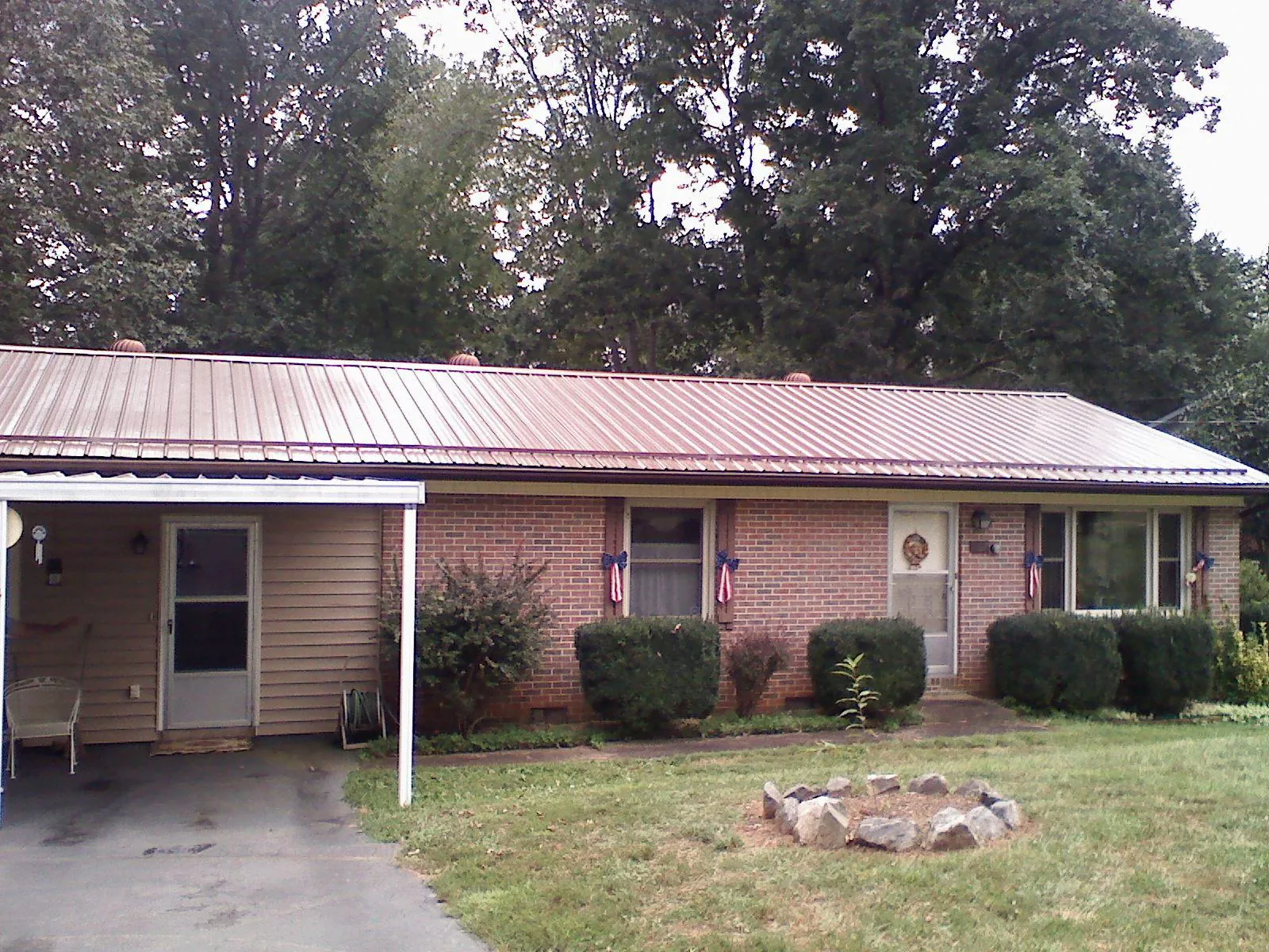 Bronze metal roof and carport on a brick ranch home — Roof Repair work by our crew in Chadwicks