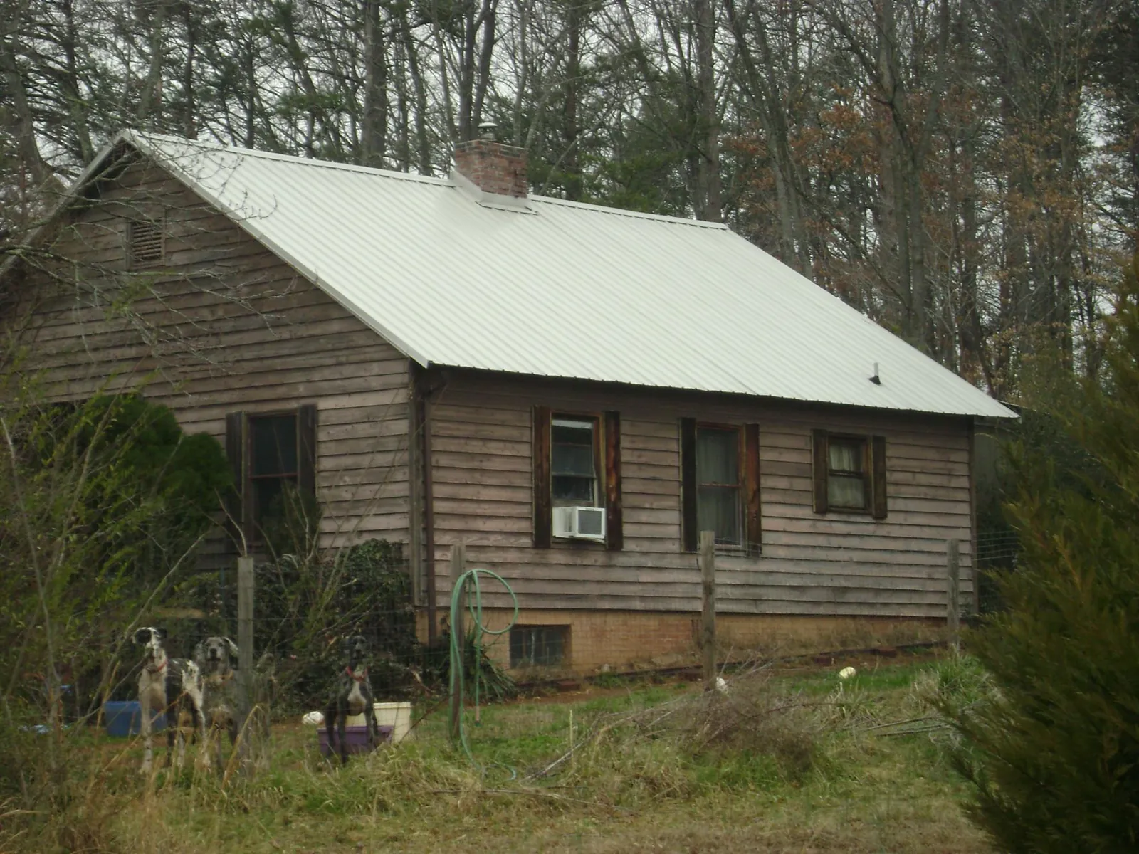 White metal roof on an old wood sided farmhouse, from a Metal Roof Installation job in Chadwicks
